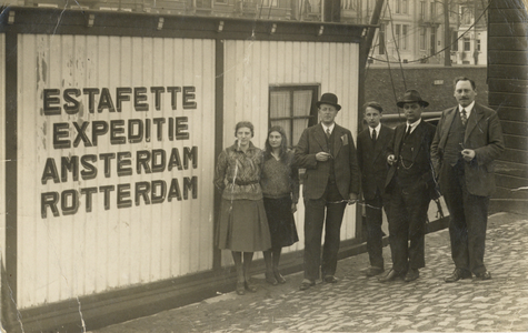 818421 Afbeelding van enkele medewerkers voor het kantoor van de N.V. Rederij Estafette aan de Rijnkade te Utrecht.